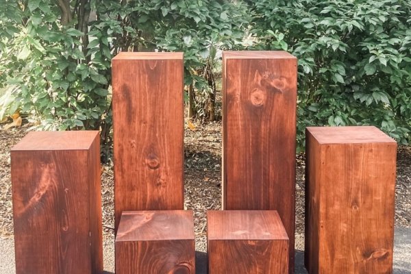 Set of wooden pillars in two heights, tall pedestals and short cubes