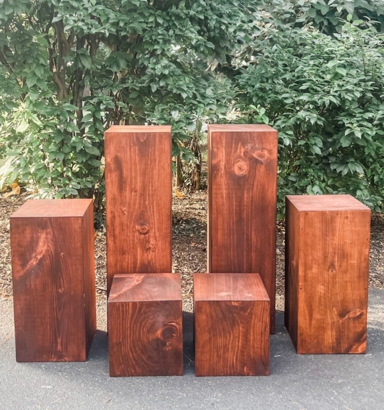 Set of wooden pillars in two heights, tall pedestals and short cubes