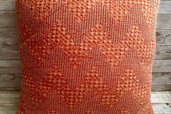 Coral woven diamond pattern rental pillow