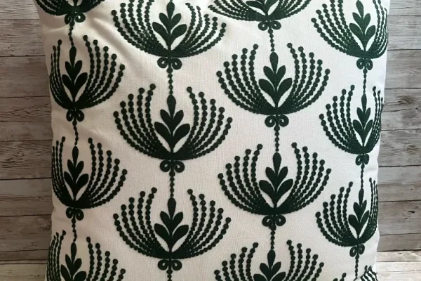 Ivory rental pillow with forest green fan pattern