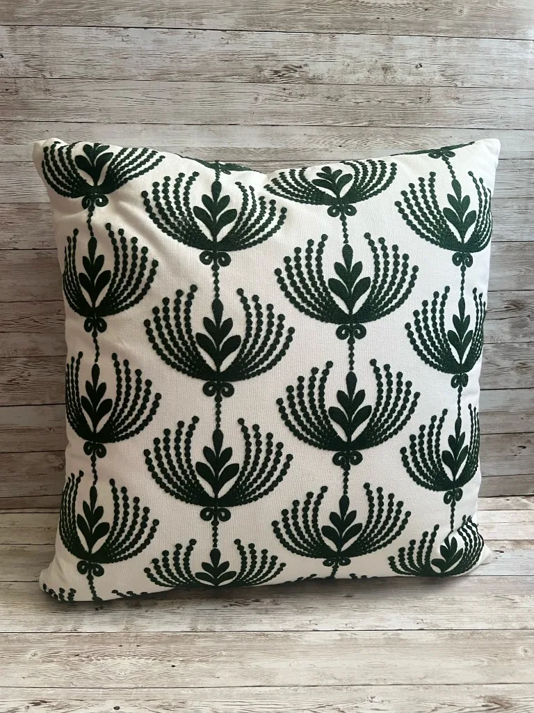 Ivory rental pillow with forest green fan pattern