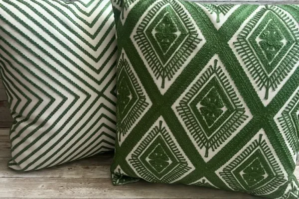 Reversible forest green and ivory geometric rental pillow shown from both sides