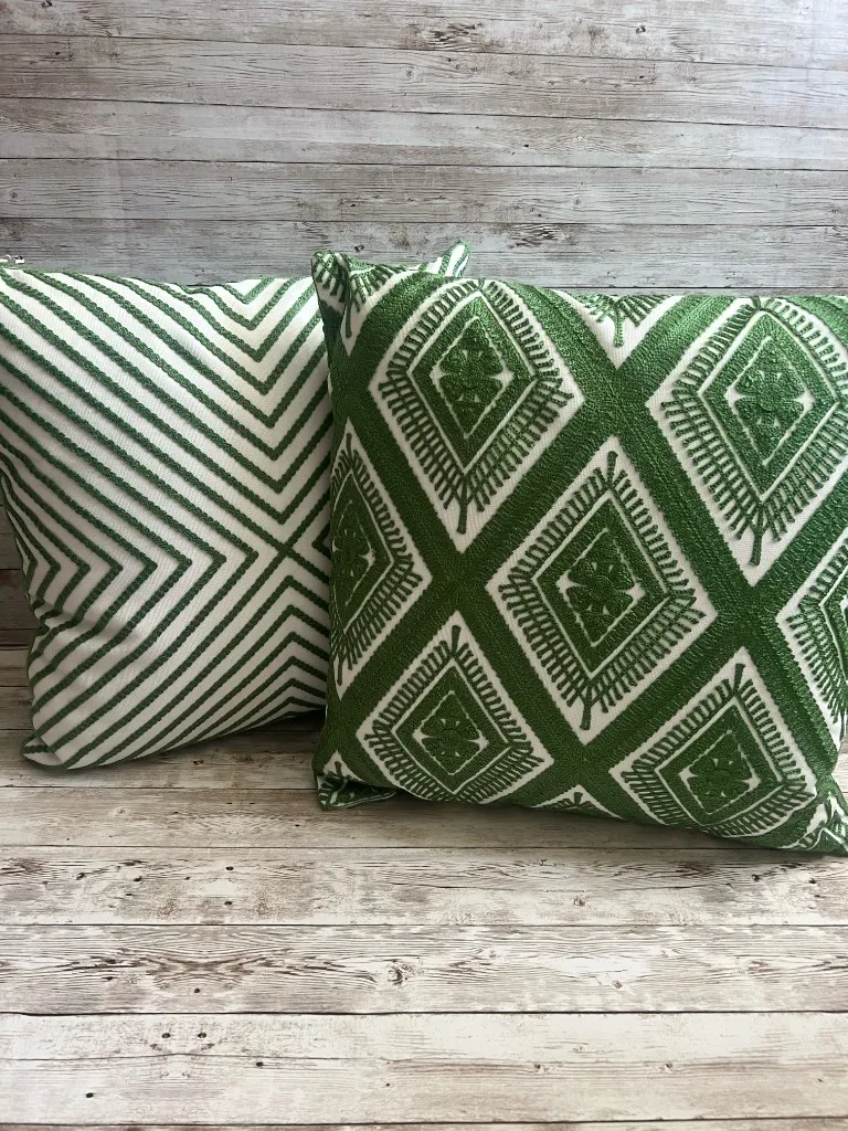 Reversible forest green and ivory geometric rental pillow shown from both sides